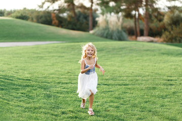 Fototapeta premium beautiful girl with long golden hair running toward funny smiling