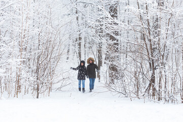 Happy loving couple having fun outdoors in snow park. Winter vacation