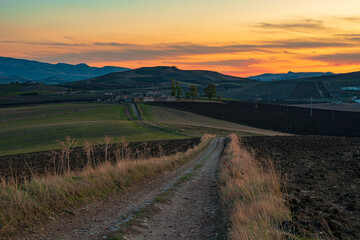 Strada di campagna dell'entroterra Siciliano al crepuscolo, Italia