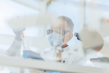 scientist sitting using an automatic dispenser for his research.