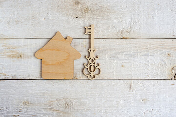 Wooden model of the house and a key. Concept of real estate transactions