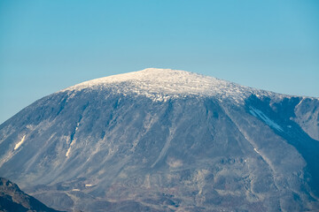 Snow covered mountain peak with clear blue skies.