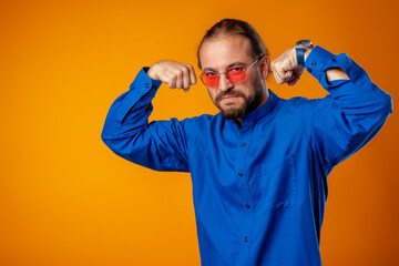 Naklejka premium Bearded man in shirt showing bicep and looking at camera