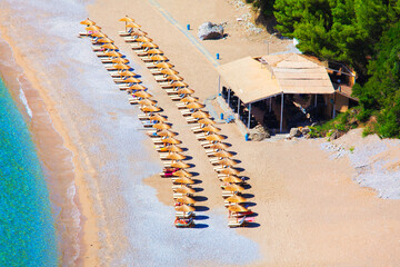 Exotic beach view from above . No people on the beach . Tropical coast with umbrellas 