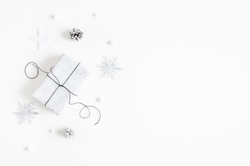 Christmas composition. Gift box, silver decorations on white background. Christmas, winter, new year concept. Flat lay, top view, copy space
