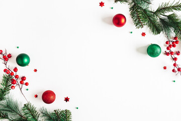 Christmas composition. Fir tree branches, red and green decorations on white background. Christmas, winter, new year concept. Flat lay, top view, copy space