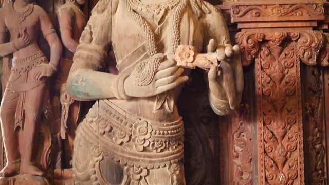 Wooden sculpture inside Thai temple of Hindu goddess of wealth Lakshmi, pan down