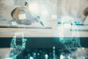 E-mail envelop theme hologram over hands taking notes background. Concept of electronic mail....