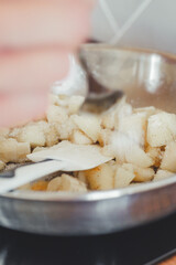 Process of frying banana and apple filling in a pan.