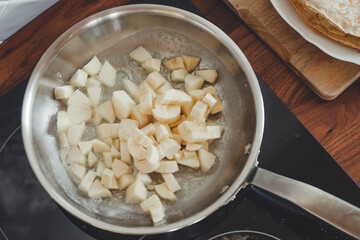 Process of frying banana and apple filling in a pan.