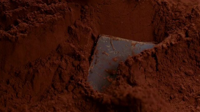 Organic hand-crafted chocolate truffles falling down in cocoa powder making amaizing splash, close-up, slow motion. Natural delicious dessert, candymaking, homemade sweets production, confectionery
