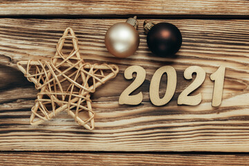 Christmas card with golden numbers, balls and a star on a wooden background. Festive New Year background. Close up.