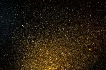 Fototapeta na wymiar Golden drops of splattered acrylic paint on a black background.