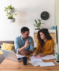 Serious husband showing calculator to his wife