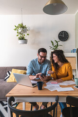 Happy husband and wife manage finances together at home