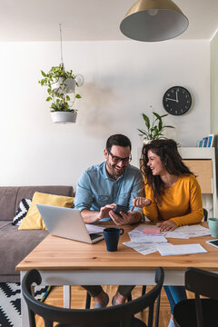 Happy Husband And Wife Manage Finances Together At Home