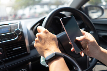 Man driving car using mobile phone texting message.