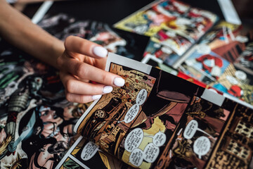 Fototapeta premium hand flipping through comic book pages. Comics background. Rostov-on-Don, Russia. 1 August 2019