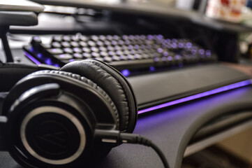 Obraz na płótnie Canvas Music headphones next to computer keyboard - standing desk
