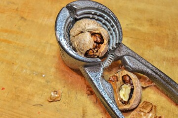 shelled walnut kernels and cracker. Walnut and walnut cracker  on the wooden table.