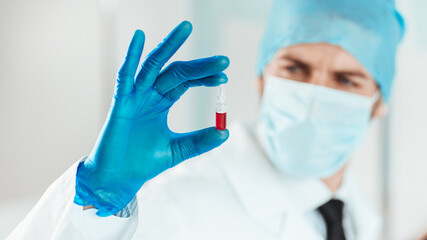 close up. ampoule with a vaccine in the hands of a scientist.