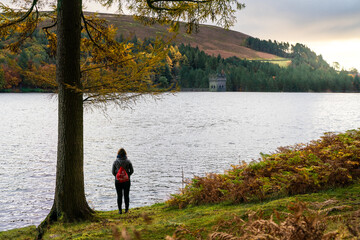 A women stood by the river at sunrise
