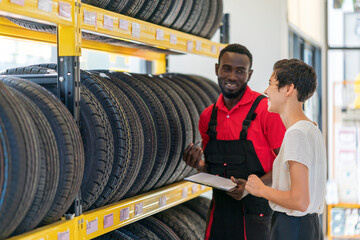 A technician provide service and talking to a customer in the auto service canter/tires service...