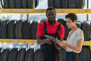 A technician provide service and talking to a customer in the auto service canter/tires service center