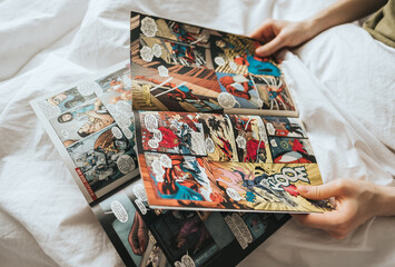 Naklejka premium Woman reading comic book in the bed at home. Rostov-on-Don, Russia. 14 April 2020