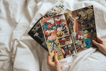 Naklejka premium Woman reading comic book in the bed at home. Rostov-on-Don, Russia. 14 April 2020