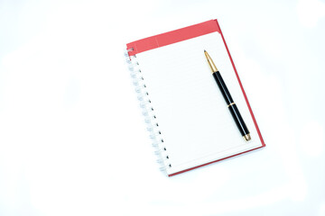 black luxury pen above blank diary paper sheet on white background