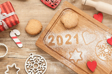 Fototapeta na wymiar Christmas and New Year 2021 background with ingredients for cooking christmas baking decorated with fir tree. New Year's decor, homemade cookies preparing for the holiday.