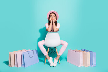 Full body photo upset girl sit chair with shopping bags look empty space difficult choice concept isolated on turquoise color background