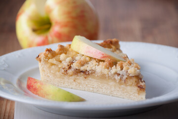 Piece of pie with apples and  apple wedge on a pie