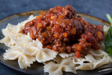 Meat sauce with pasta on a gray plate