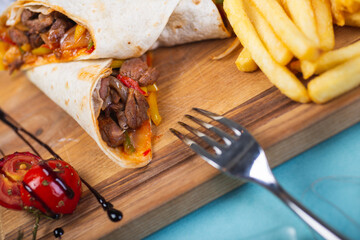 Traditional Caucasian meat in a tortilla with spices and seasonings is wrapped in a tube.