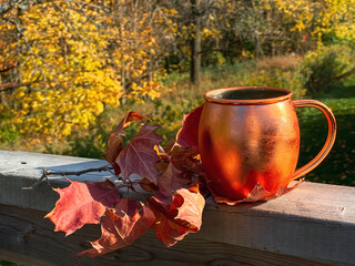 autumn still life with copper mug and oak leaves