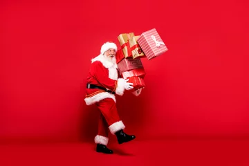 Santa Claus with a lot of gifts on a red background. © neonshot