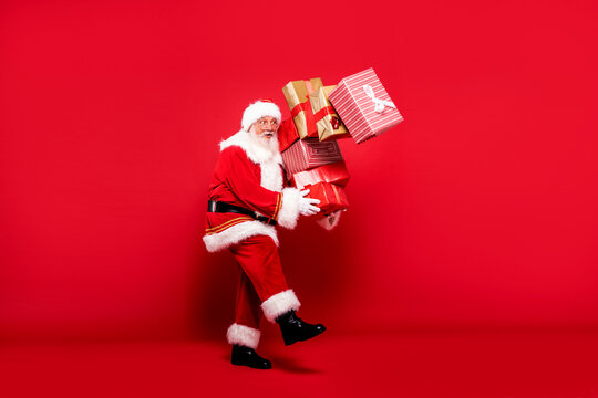 Santa Claus with a lot of gifts on a red background.