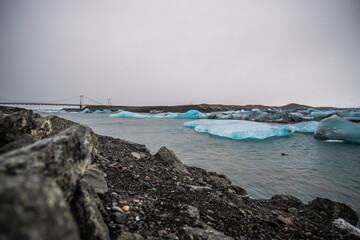 beach and rocks with ice floating in river