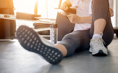Asian woman workout and working online alone at GYM. Social distancing and new normal lifestyle.