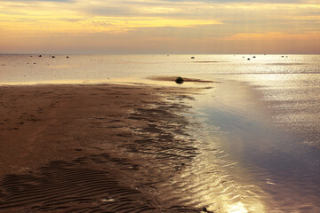 the sand spit with footprints at sunset time on the sea