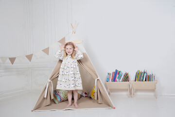 a girl plays with toys in a teepee