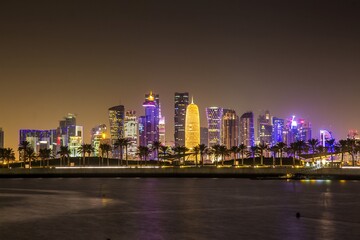 Fototapeta premium DOHA, QATAR - OCTOBER 27, 2017: Beautifully illuminated skyscrapers of Doha business city center at night. Qatar.