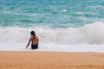 tanned children in a swimsuit on the beach play on the sand. Atlantic coast, Benagil beach in Portugal.