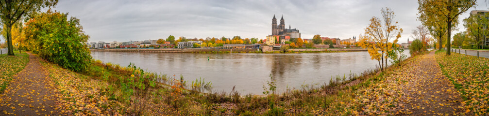 Obraz premium Panoramic view over downtown of Magdeburg, old town, Elbe river and Magnificent Cathedral at early Autumn and warm sunset, Magdeburg, Germany.