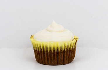 Carrot cake cupcake close up with a white background