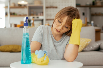 Sad woman cleaning home. Young tired woman at home.