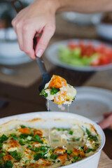 Housewife lays on plates traditional pumpkin pie with turkey and baked vegetables.