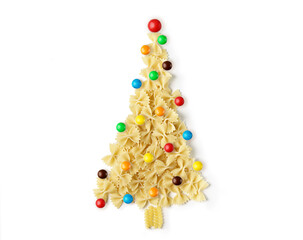 Christmas tree made of raw italian pasta with color baubles isolated on a white background. Winter holidays concept